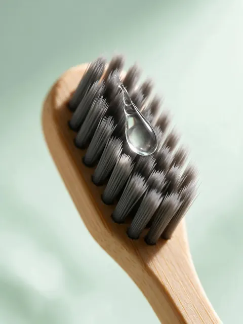 Bamboo toothbrush macro: AI-generated macro product image of a bamboo toothbrush with a water drop