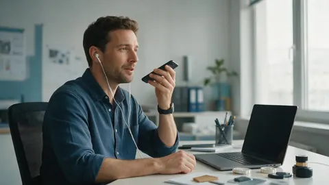 A man listening to a voice message with earbuds at an office desk