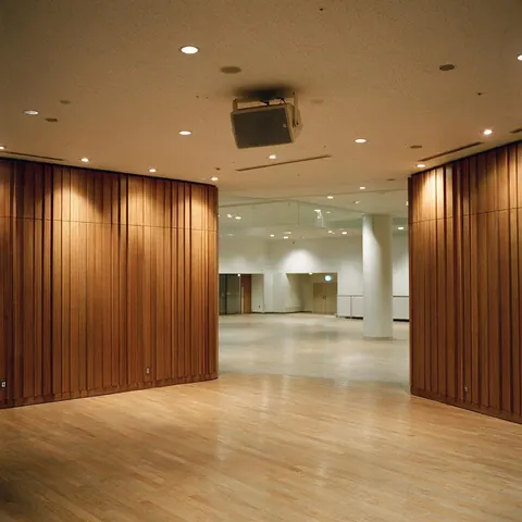 Empty concert hall foyer with a ceiling loudspeaker and warm lights