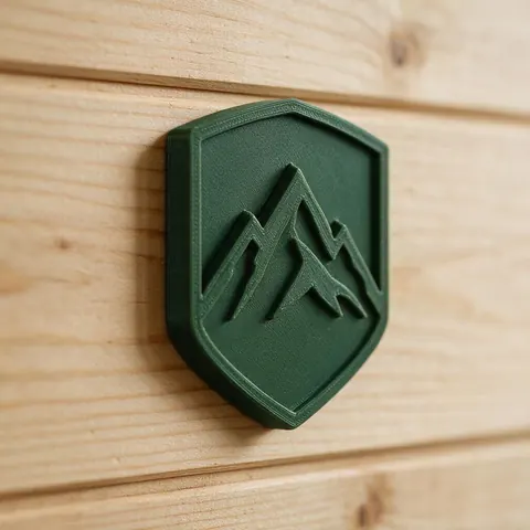 3D printed mountain emblem badge on a wooden wall