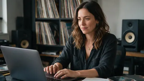 A label manager at a desk with vinyl records and studio monitors