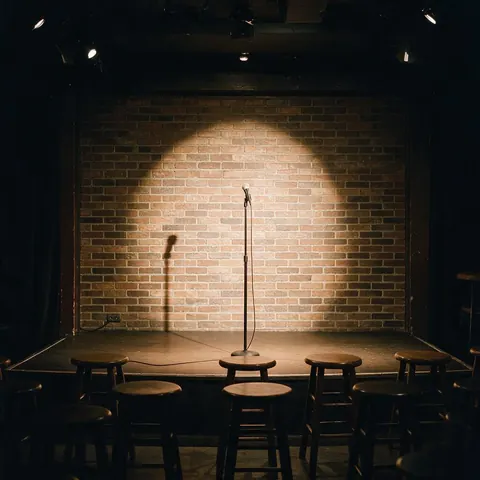 Microphone on a stand in a spotlight on a small comedy club stage