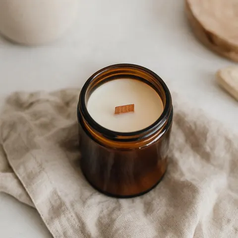 Top-down photo of a handmade amber candle on linen