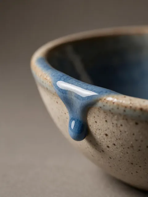 Ceramic glaze macro: AI-generated closeup of a handmade bowl's dripping glaze