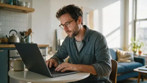 A founder working on a laptop at a kitchen table