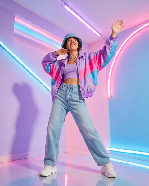 Vertical video frame of a woman in a colorful jacket dancing in a pastel neon-lit studio