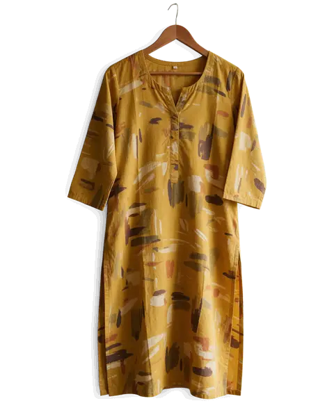 Mustard printed cotton kurti on a hanger on a bedroom door