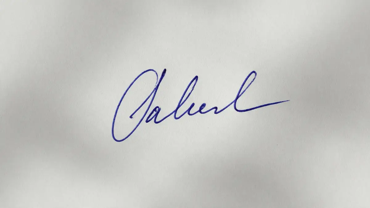 Handwritten blue ink signature on paper — before