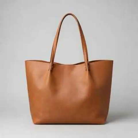 Tan leather tote bag on a light grey background