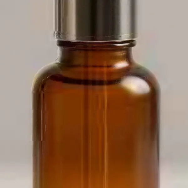 Amber glass serum bottle with a dropper on a beige stone — the same crop after Image Upscaler