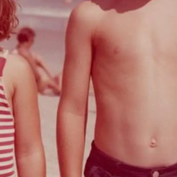 Faded 1970s colour snapshot of two children on a beach with a red-magenta cast — the Scanned print, faded original stretched to the same size (bicubic)