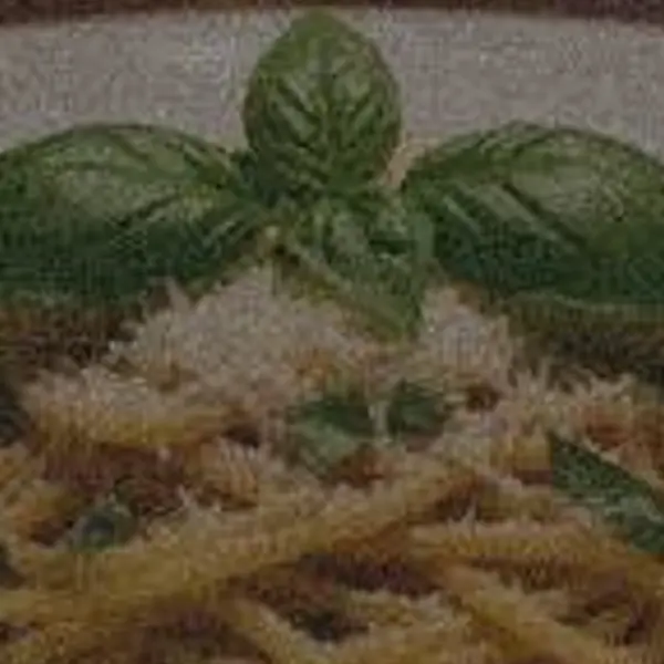 Plate of pasta with basil in a dim candle-lit restaurant — the 640 px, noisy original stretched to the same size (bicubic)