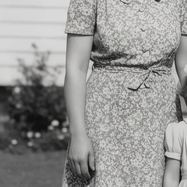 Faded 1950s black-and-white family photo in front of a house, with scratches and a torn corner — the same crop after Phota Enhance