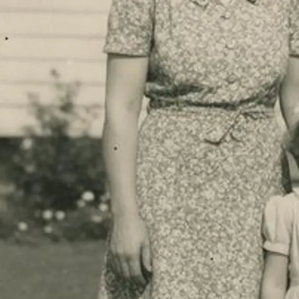 Faded 1950s black-and-white family photo in front of a house, with scratches and a torn corner — the Scanned print original stretched to the same size (bicubic)
