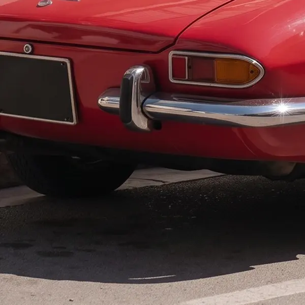 Red vintage convertible on a sunny street with white buildings and blue shutters — the same crop after Phota Enhance