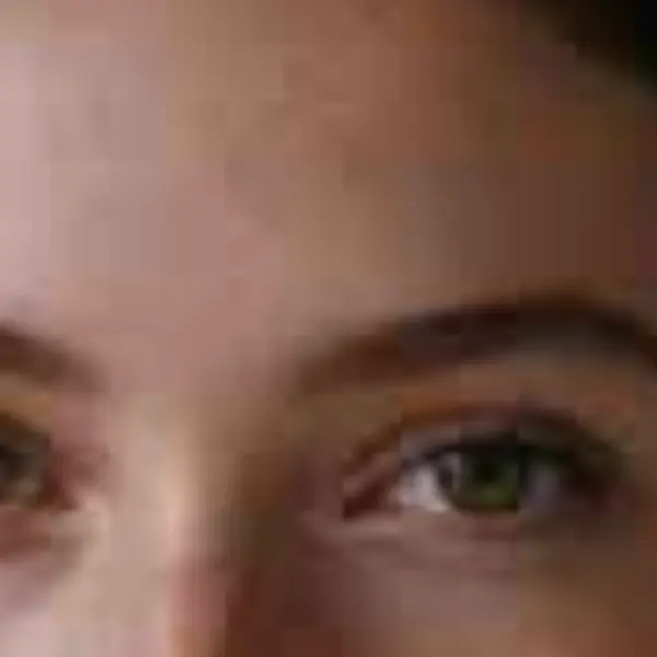 Close-up portrait of a young woman with freckles and dark curly hair — the 300 px JPEG original stretched to the same size (bicubic)