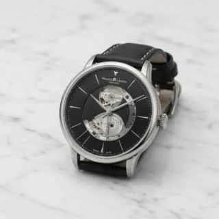 Silver wristwatch with a black leather strap on white marble — before